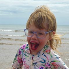 Elodie, smiling and playing on the beach.